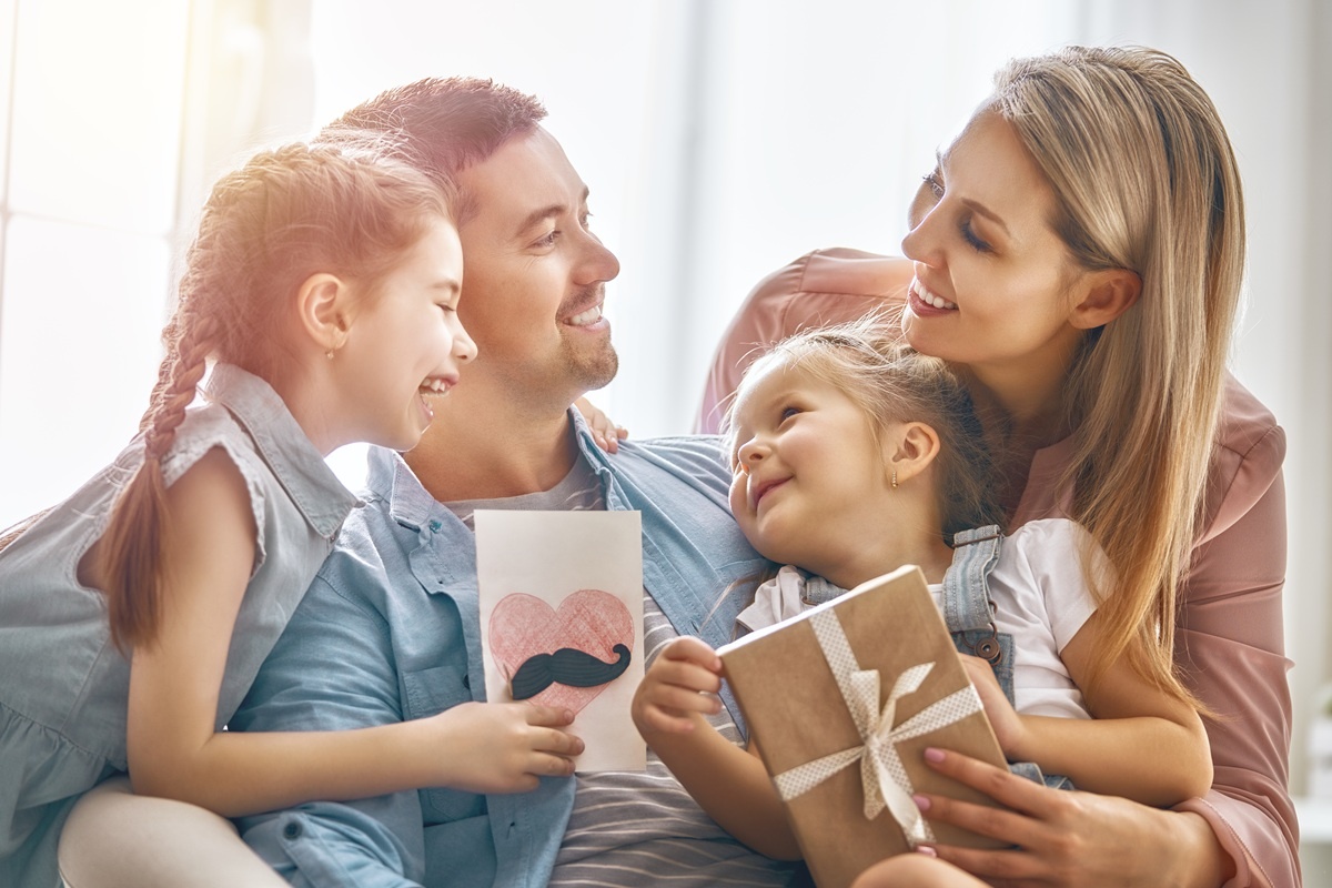 Familia îi oferă tatălui un cadou de Ziua Tatălui Familia îi oferă tatălui un cadou de Ziua Tatălui