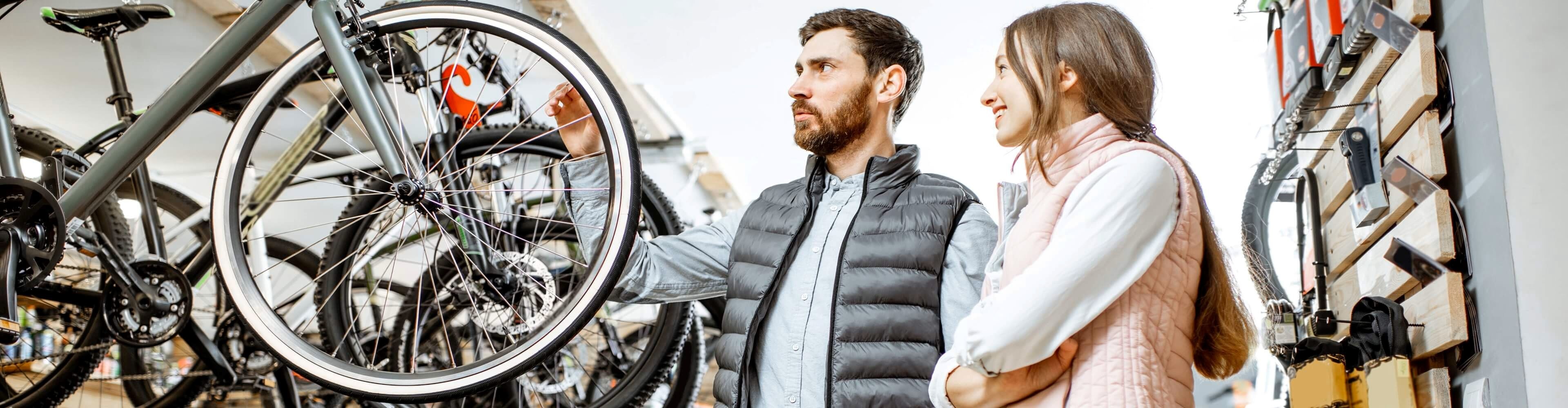 Un cuplu își alege mărimea corectă a bicicletei la magazin