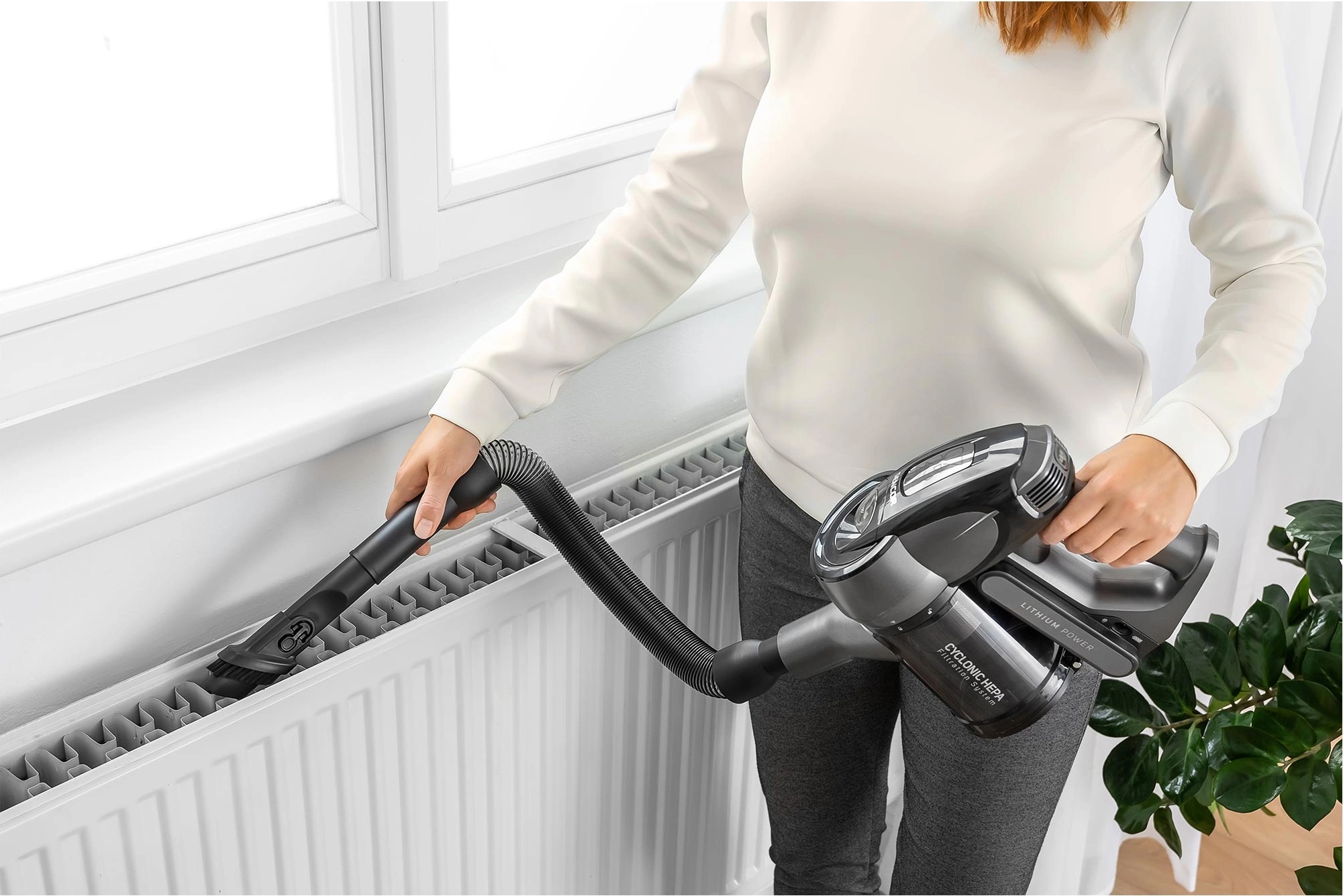 Vysávání i špatně přístupných míst bude se Sencor SVC 0725BK hračka Žena při úklidu radiátoru s vysavačem Sencor SVC 0725BK