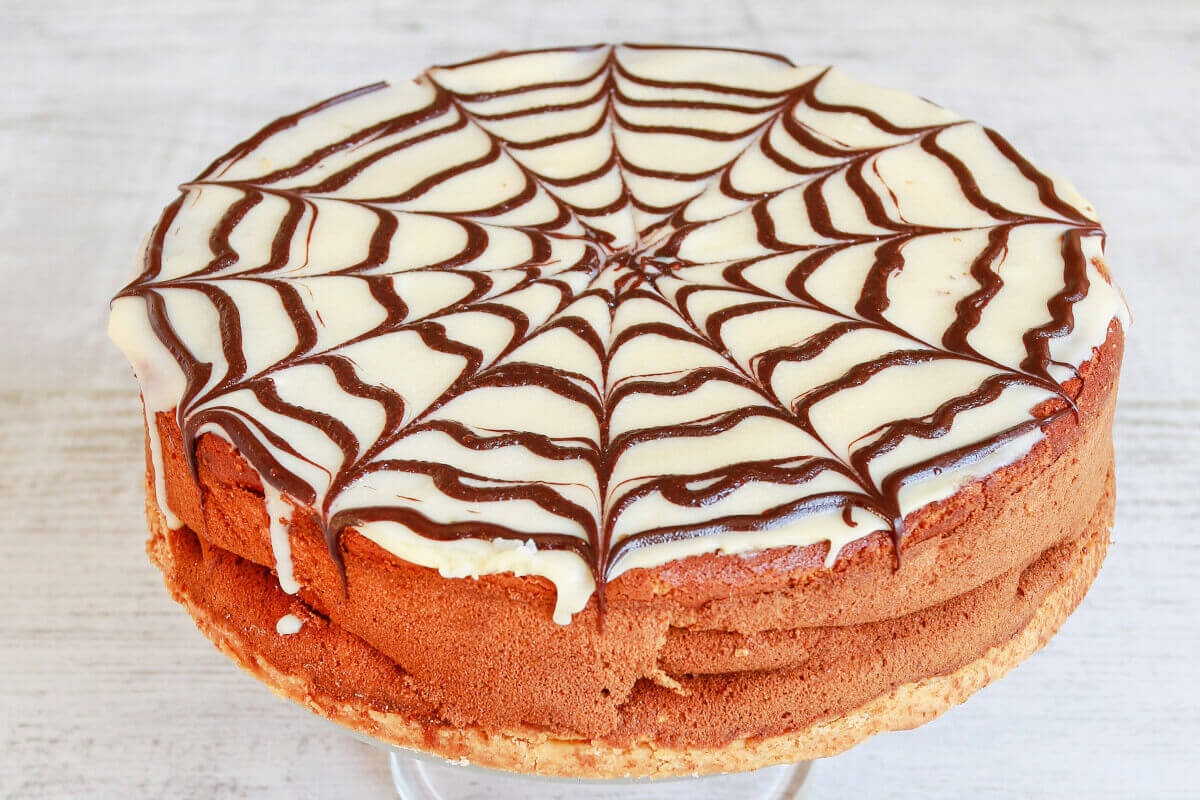 Plăcintă cu dovleac ornată cu glazură cu aspect de pânză de păianjen de Halloween Plăcintă cu dovleac ornată cu glazură cu aspect de pânză de păianjen de Halloween