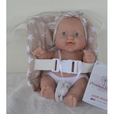 Marina & Pau Realistické miminko holčička smějící se Maruška ve světle hnědé autosedačce s bílými hvězdičkami Cookie Baby 20 cm