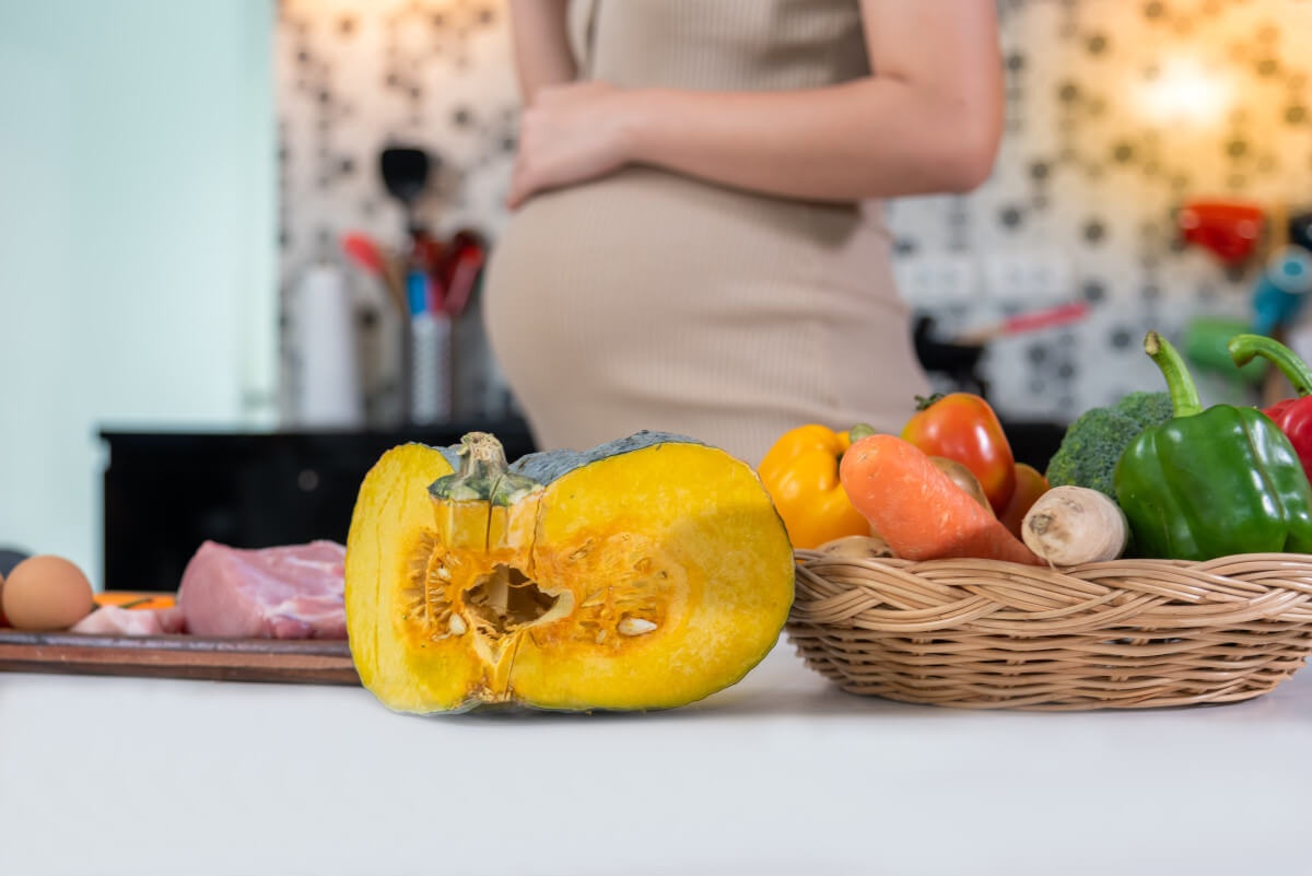 Terhes nő tököt dolgoz fel főzés közben