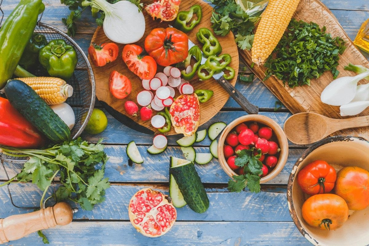 Varietate de legume proaspete și fructe crude feliate pe tocătoare de lemn - ingredientele naturale pentru dieta de detoxifiere a organismului