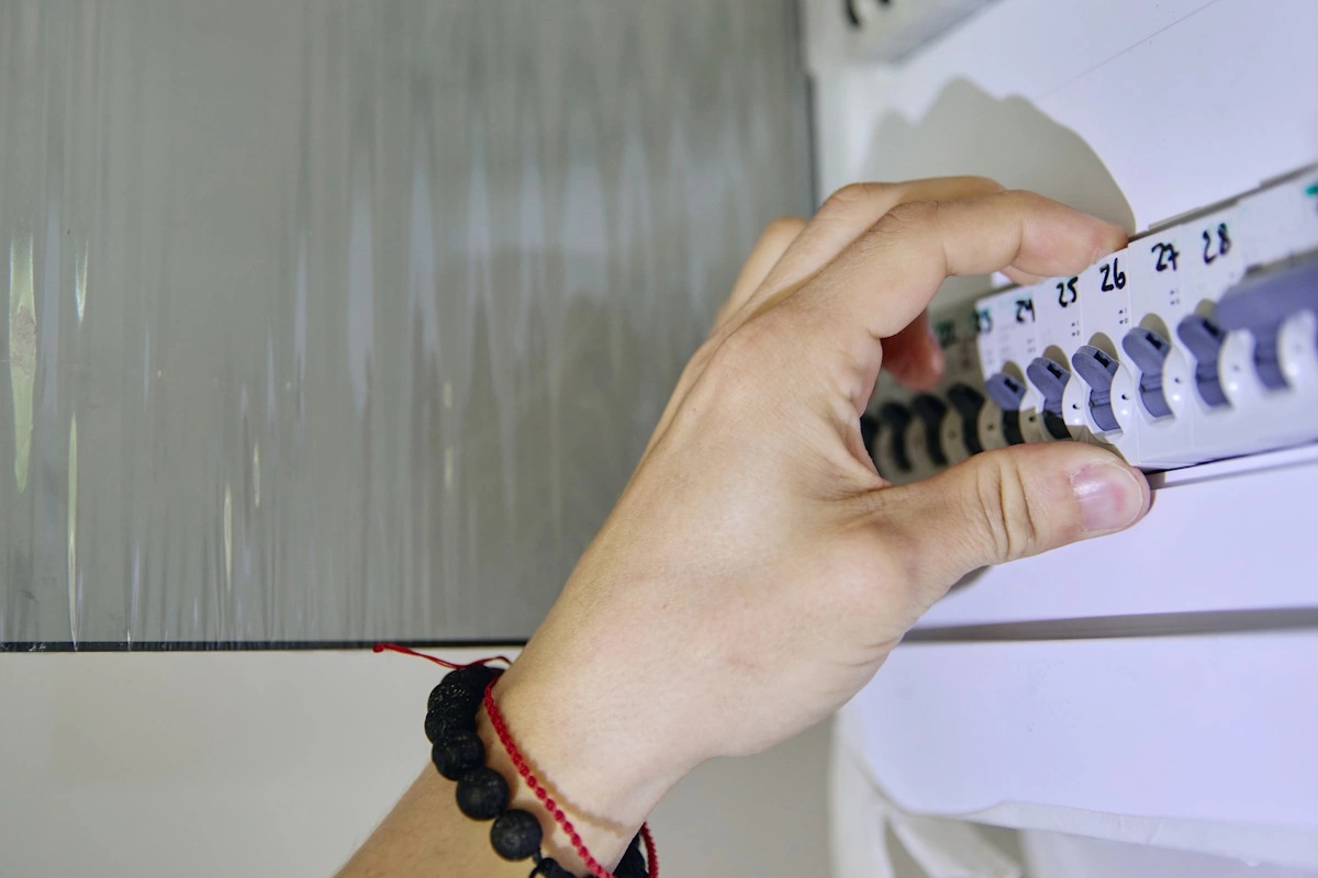 Detail na ruku ovládající elektrický jistič Detail na ruku ovládající elektrický jistič