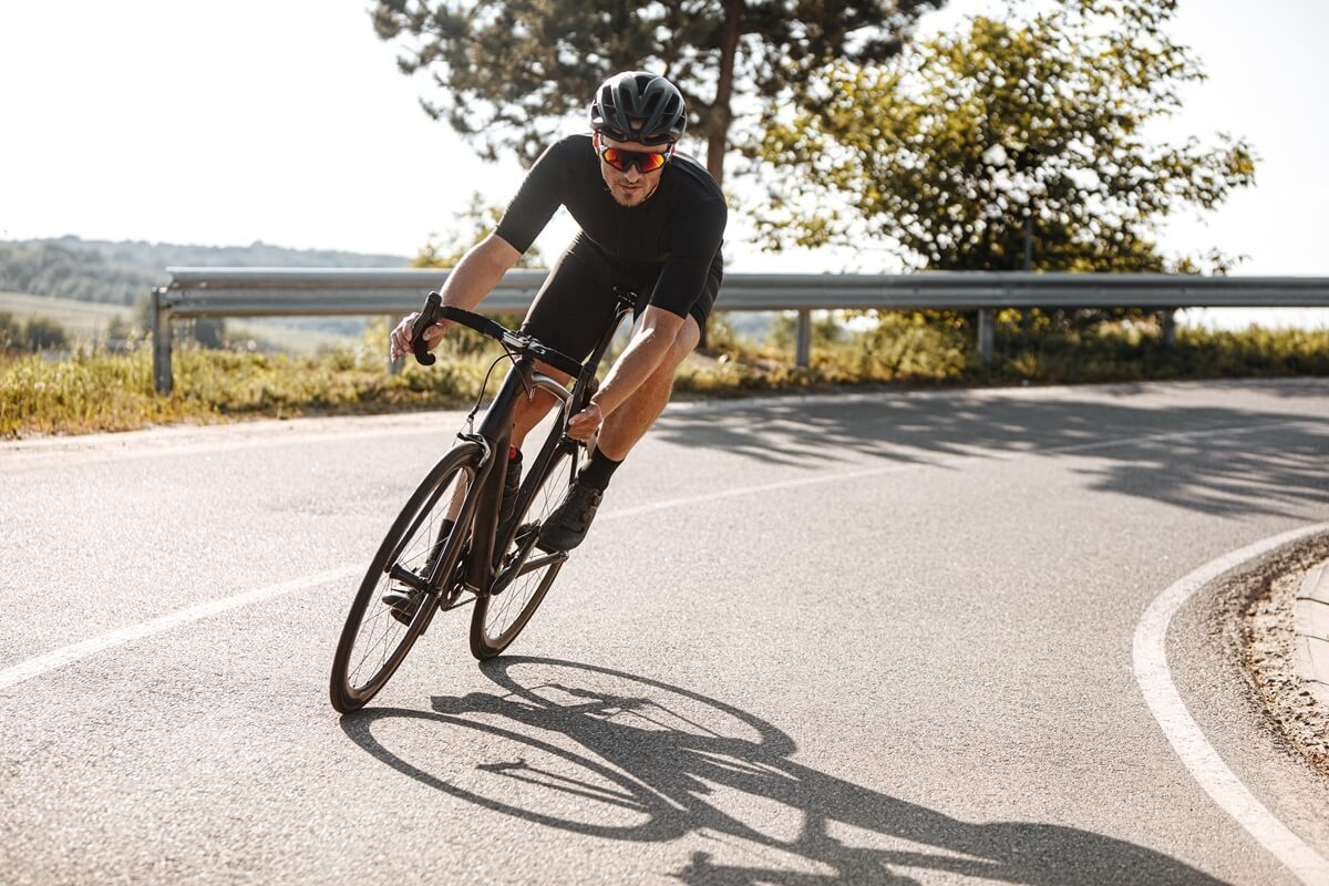 Cyklista na silničním kole vybírá zatáčku.
