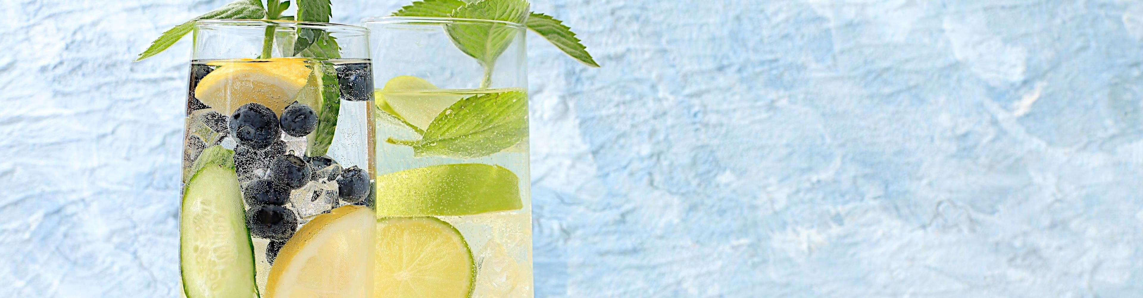 Pahare cu apă infuzată cu fructe, citrice, castravete și mentă - băuturi revigorante și naturale pentru o cură de detoxifiere
