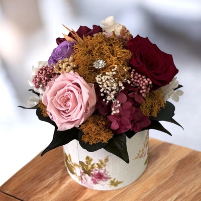 Menšia kytica farebných stabilizovaných kvetov vo flower boxe v