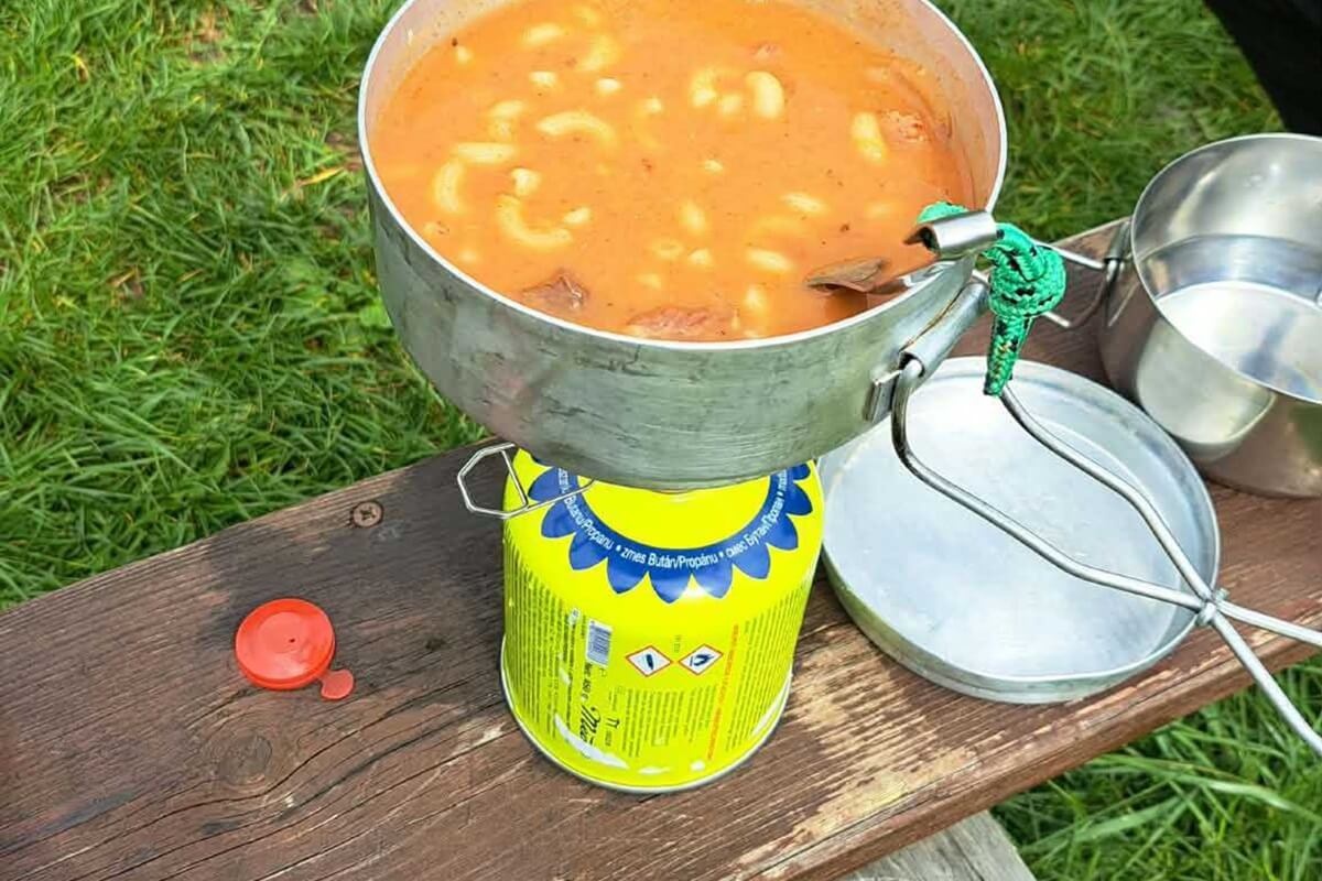Marhahúsos gulyás készül alumínium edényben, kempingfőzőn