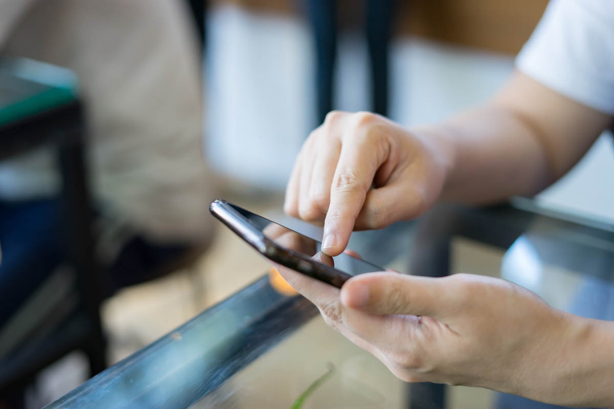 Fiatal férfi mobiltelefonnal a kezében